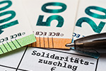 Schriftzug Solidaritätszuschlag und Geldscheine
